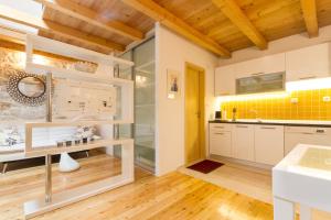 a kitchen with white cabinets and yellow tiles at Apartments Vica in Šibenik