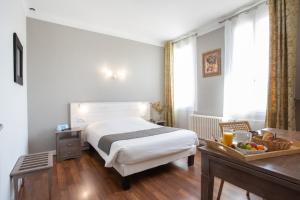 Rúm í herbergi á Logis Hotel L'Occitan 2 étoiles