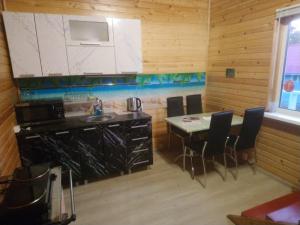 ラフデンポヒヤにあるCottedzh Sorolaのキッチン(カウンター、テーブル、椅子付)