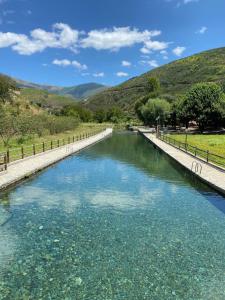 a canal of water with mountains in the background at Casa da Alfazema in Arganil