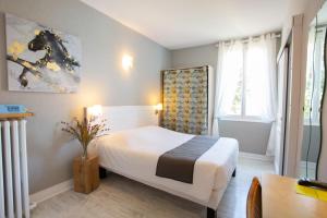 Katil atau katil-katil dalam bilik di Logis Hotel L'Occitan 2 étoiles