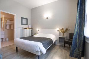 Rúm í herbergi á Logis Hotel L'Occitan 2 étoiles