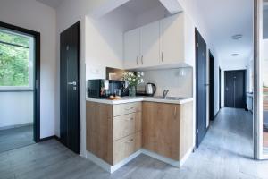 a kitchen with white walls and wooden cabinets at RJ Hostel Chrobrego 79 in Gdańsk