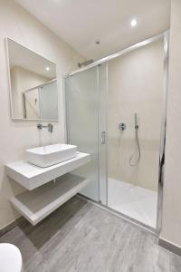 a bathroom with a glass shower and a sink at VL Central Room in Olbia