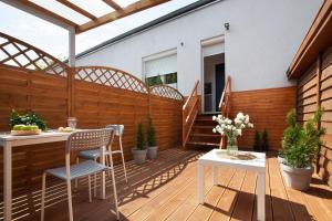 a patio with a table and chairs on a wooden deck at RJ Hostel Chrobrego 79 in Gdańsk