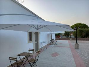 a patio with tables and chairs and an umbrella at Green Sea Bed & Breakfast in Elena Marina