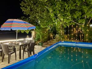 - une terrasse avec une table et un parasol à côté de la piscine dans l'établissement Hotel 9th Sky, à Koutaïssi
