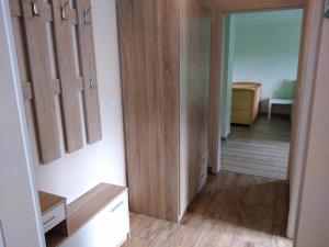 a hallway with wooden cabinets and a room with a table at Untere Ferienwohnung Asshoff in Ahorn in Berolzheim