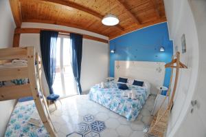 una camera da letto con pareti blu, un letto e una scala di Maison C&G a Pachino