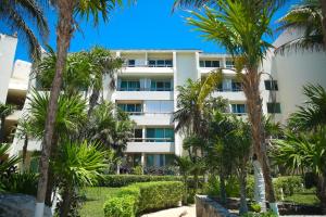 um edifício branco com palmeiras em frente em Solymar Beach Condos em Cancún