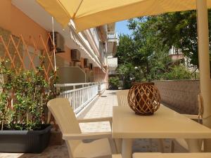 una mesa y sillas en un balcón con sombrilla en Villa Vienni, en Paralia Katerinis