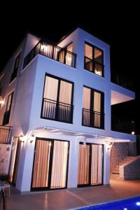 Villa myra في دمرة: مبنى أبيض كبير مع نوافذ في الليل