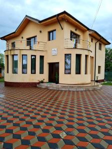 uma casa com um grande pátio de tijolos em frente em Vila NICHOLAS em Bărcăneşti