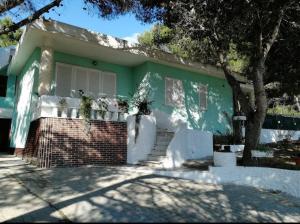 a green house with stairs and a tree at Georgia in Porto Pino