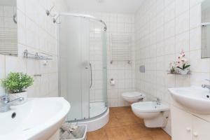 a bathroom with a sink and a toilet and a shower at Akademikus Toruń in Toruń