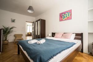 a bedroom with a large bed with towels on it at oompH Warsaw Modern Apartment near Nowy Świat in Warsaw