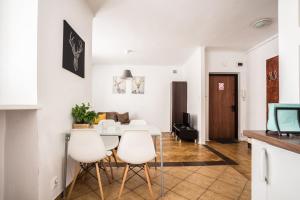 a kitchen and living room with a table and chairs at oompH Warsaw Modern Apartment near Nowy Świat in Warsaw