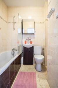 ein Badezimmer mit einer Badewanne, einem WC und einem Waschbecken in der Unterkunft oompH Warsaw Modern Apartment near Nowy Świat in Warschau