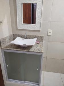 a bathroom with a sink and a mirror on a counter at Triplex Costazul Temporada in Rio das Ostras +18 photos