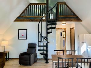 a spiral staircase in a living room with a table and a chair at Calm Waters Resort in Branson