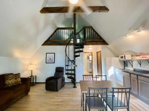 a living room and kitchen with a spiral staircase in a loft at Calm Waters Resort in Branson