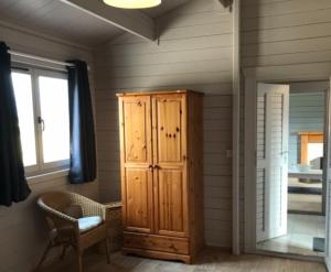 Habitación con armario de madera y ventana. en Lovely 1-Bed House in Fochabers Scotland, en Fochabers