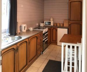 a kitchen with wooden cabinets and a stove top oven at Lovely 1-Bed House in Fochabers Scotland in Fochabers