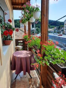 una pequeña mesa en un balcón con flores en Pensiunea Cristiana, en Curtea de Argeş