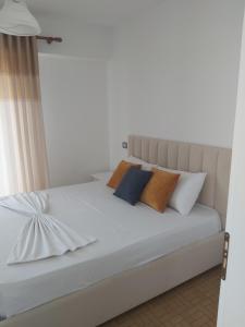 a bedroom with a white bed with pillows at Seafront apartment in Ksamil