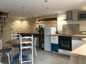 a kitchen with white appliances and a table and chairs at Les tilleuls de Mary in Rillé