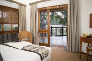 1 dormitorio con 1 cama y puerta a un balcón en Kruger Park Lodge Unit 245, en Hazyview