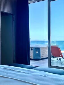 a room with a bed and a window with a chair at Demi Hotel in Sarandë