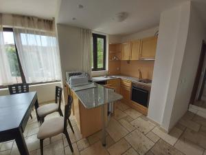 a kitchen with a counter and a table and chairs at Apartament Vallarta in Kavarna