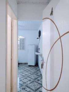 カラグアタトゥーバにあるPousada Sandramarの白い冷蔵庫が備わるタイルフロアの客室です。