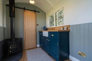 a kitchen with a blue cabinet and a stove at Bannfield shepherds hut in Ballymoney