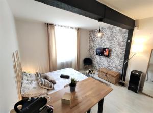 een woonkamer met een tafel en een bank bij Le Jasmin des Carmes - Hypercentre - Netflix in Toulouse