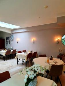 Hotel Pension Oranje في فالكنبورخ: غرفة طعام مع طاولات وكراسي وساعة على الحائط