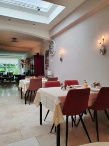 a restaurant with tables and chairs and a clock on the wall at Hotel Pension Oranje in Valkenburg