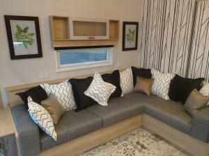 a living room with a couch with pillows on it at Chapel Fields Holiday Park in Chapel Saint Leonards