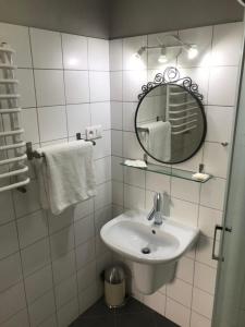 Baño blanco con lavabo y espejo en Rezydencja Sandomierska en Sandomierz