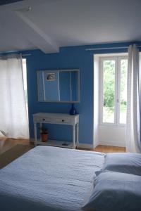 een slaapkamer met blauwe muren en een bed en een raam bij Château Le Souley in Vertheuil-en-Médoc
