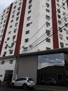 a white car parked in front of a tall building at no centro de Cuiabá aptº mobiliado in Cuiabá