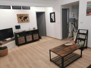 a living room with a tv and a table and a chair at Au Kaycedra in Calais