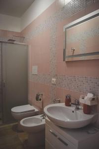 een badkamer met een wastafel, een toilet en een spiegel bij Le Radici Laviano in Laviano