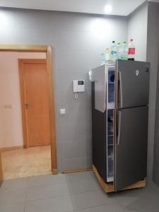 eine Küche mit einem schwarzen Kühlschrank im Zimmer in der Unterkunft Treize in Meknès