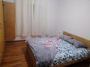 Schlafzimmer mit einem Bett mit einer blauen und weißen Bettdecke in der Unterkunft Treize in Meknès
