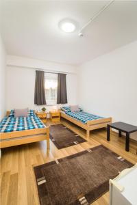 Habitación con 2 camas y 2 alfombras en Galgavölgye munkásszálló en Aszód