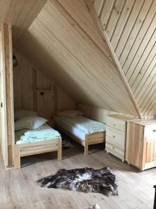 two beds in a room with a attic at Apartament u Beaty i Heńka, Łapszanka in Łapszanka