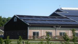 eine Scheune mit Sonnenkollektoren auf dem Dach in der Unterkunft Buiten in Bladel in Bladel