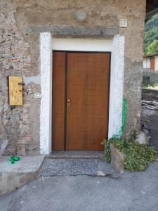 una porta in legno in un edificio in pietra con aphalt di Bed and breakfast Settesette6 a Barghe